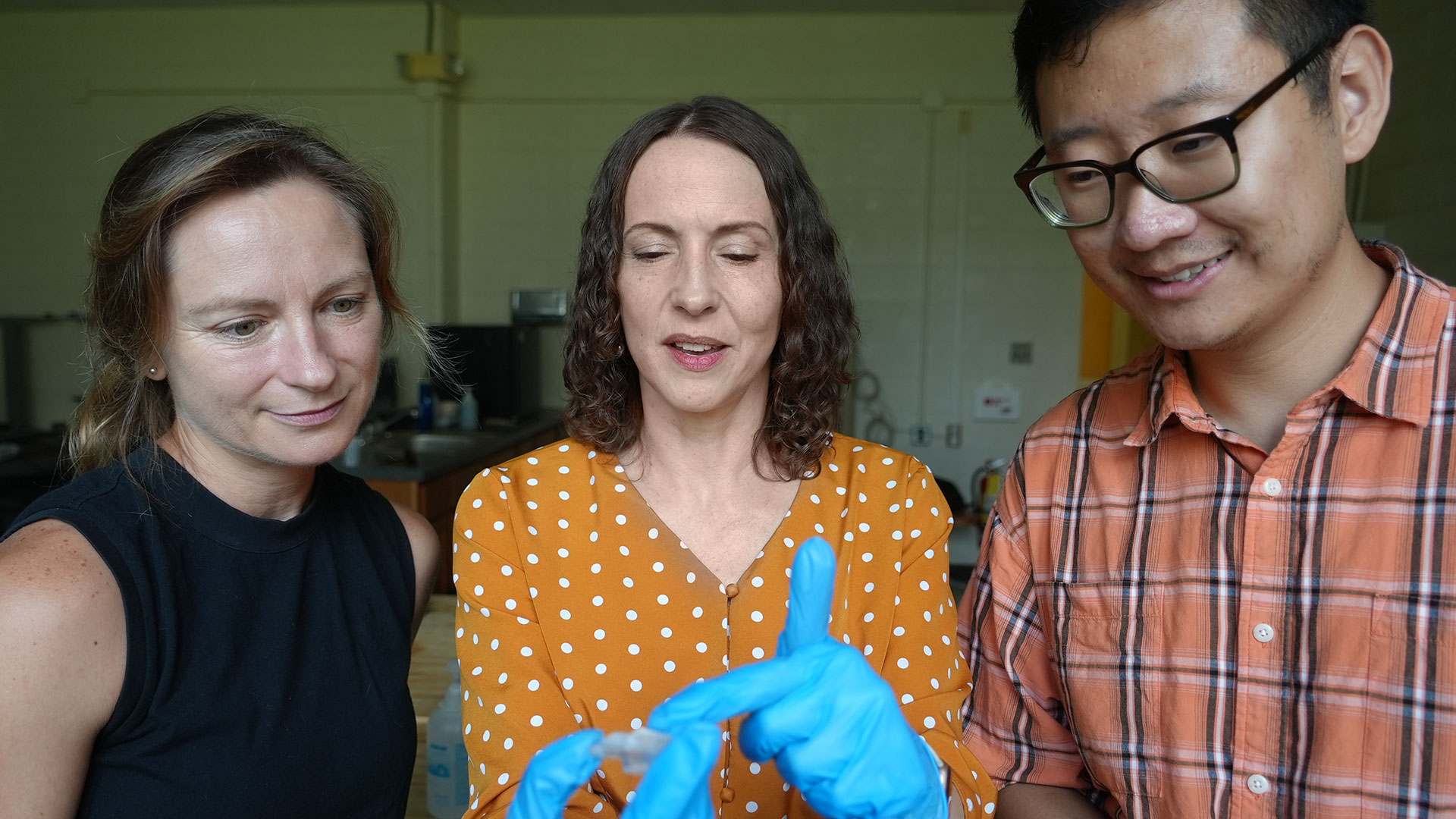 (From left) Leanna House, Anne Staples, and Ph.D. student Shuyu Zhang inspect a small pump developed in Staples' lab. Photo by Alex Parrish for Virginia Tech.