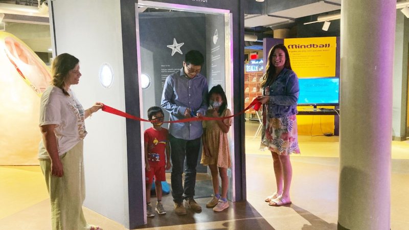 Ling Li and his children join museum staff Sherrie Jennings (left) and Shannon Allencut (right) to cut the ribbon on his starfish skeleton exhibit at the Science Museum of Western Virginia. 