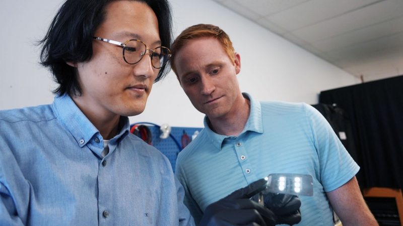 (From left) Postdoctoral researcher Dong Hae Ho and Associate Professor Michael Bartlett examine a soft electronic made with their method of producing soft circuits. Photo by Alex Parrish for Virginia Tech.