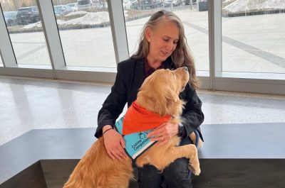 Barbara Hoopes pets Allen, a golden retriever therapy dog