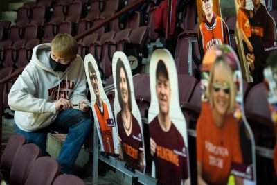 Eric Link, a junior and a member of the American Society of Mechanical Engineers at Virginia Tech, puts the final touches on the moving Hokie cutouts at Cassell Coliseum. Photo by Ryan Young.