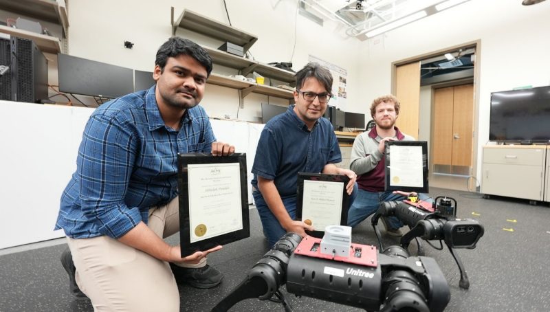 Abhishek Pandala, Kaveh Akbari Hamed, and Randall Fawcett show their ASME award certificates in the Hybrid Dynamic Systems and Robot Locomotion Lab.