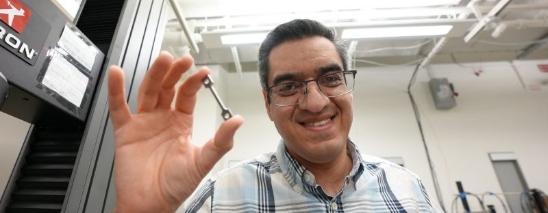 Associate Professor Reza Mirzaeifar holds a 3D-printed metal sample prepared for testing.